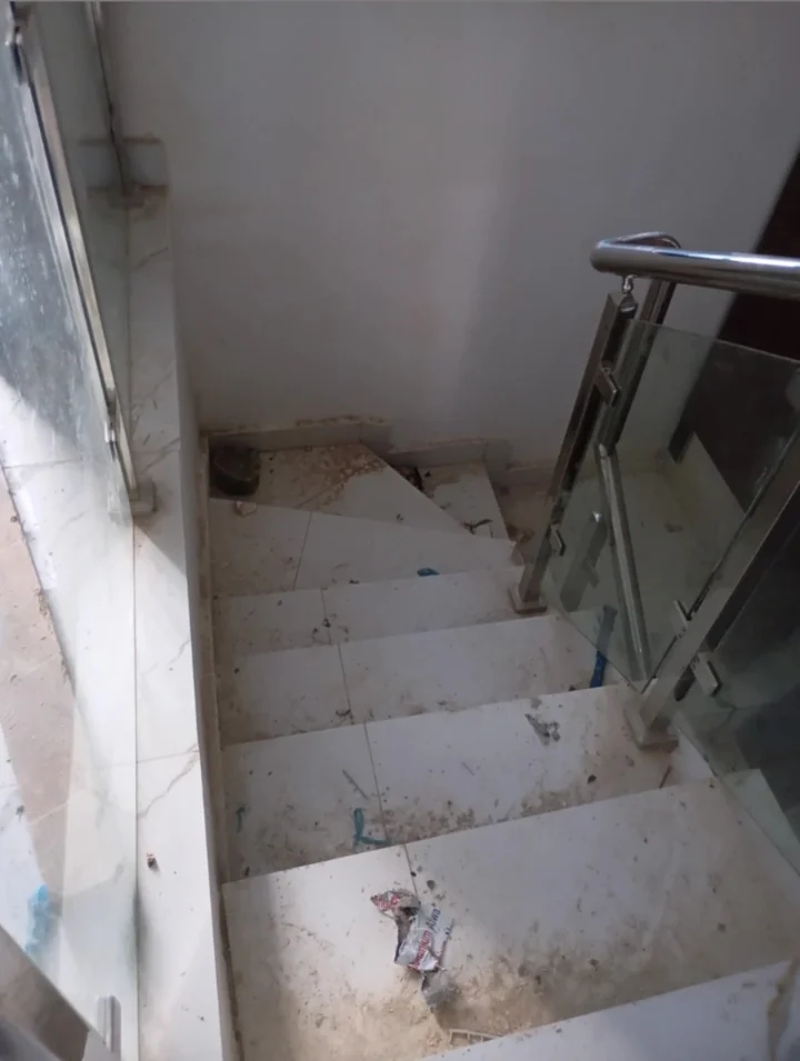 Marble staircase covered in building debris, before the clean